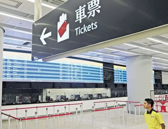 Foreign tourist scanning passport at Hong Kong West Kowloon Station turnstile