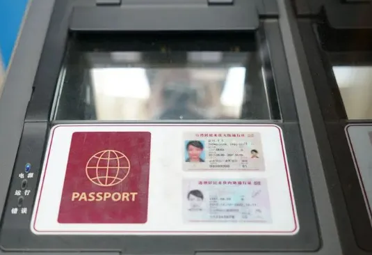 Foreign tourist scanning passport as an e-ticket at China railway station turnstile