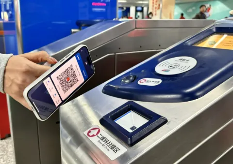 Foreigner using Alipay transport QR code at Chinese subway turnstiles